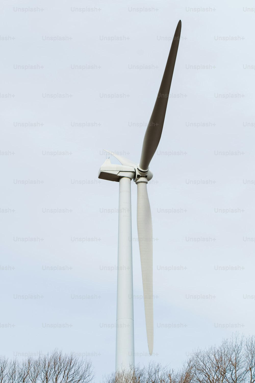 a wind turbine in a field with trees in the background