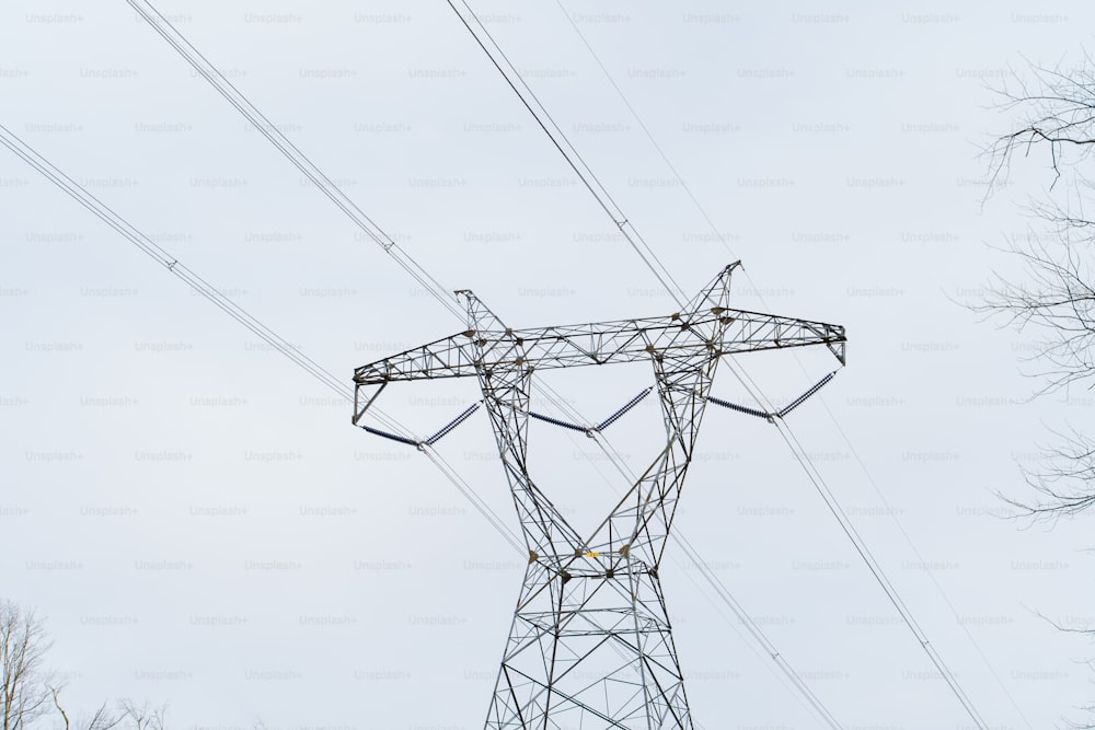 a high voltage power line with trees in the background