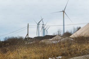 a bunch of windmills behind a barbed wire fence