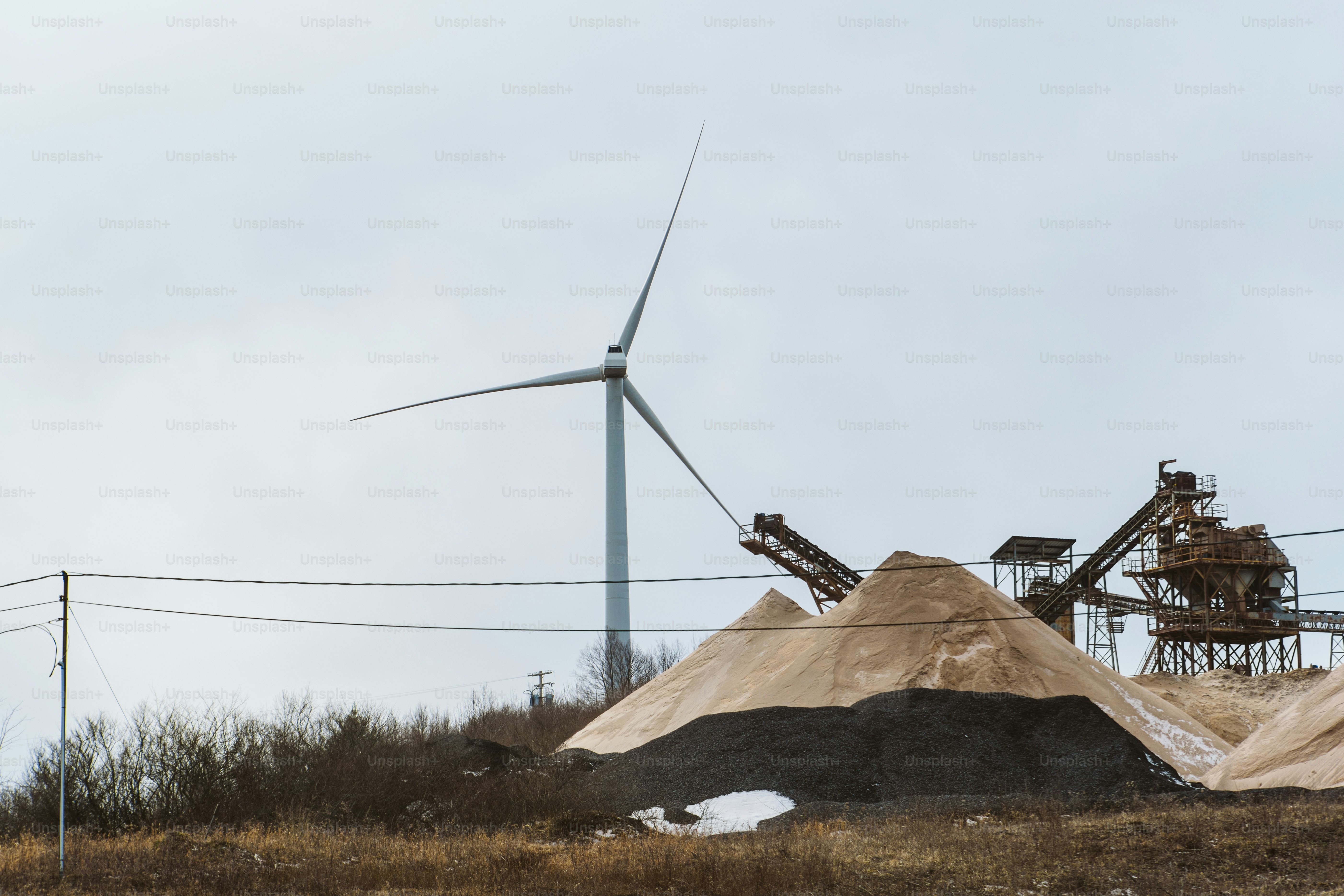a large pile of dirt next to a wind turbine