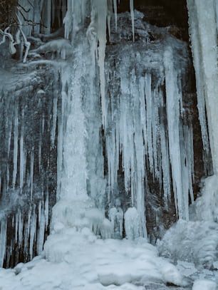 icicles are hanging from the side of a waterfall