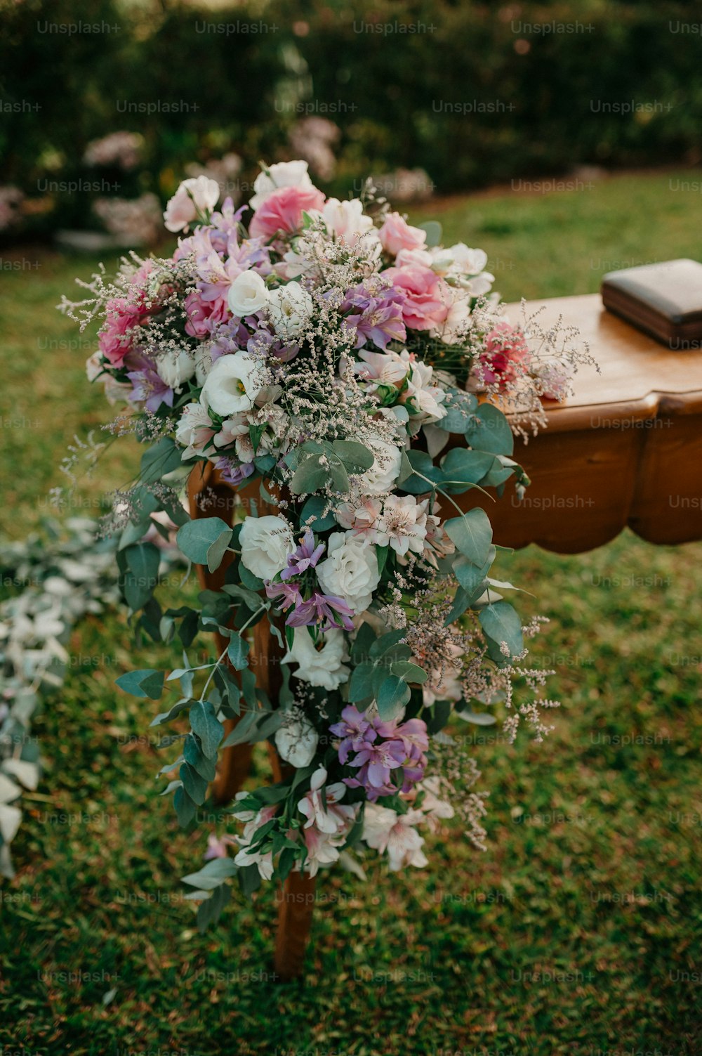 a bouquet of flowers sitting on top of a wooden bench