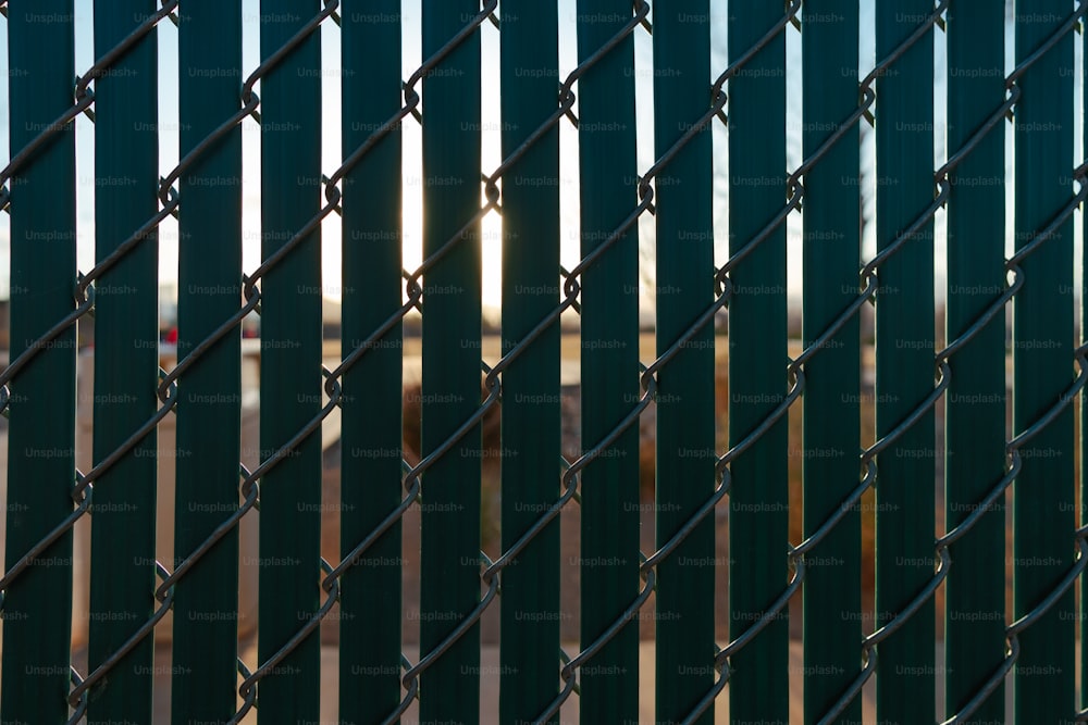 Le soleil brille à travers une clôture à mailles de chaîne