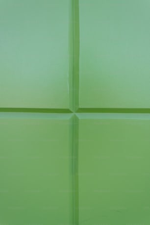 a close up of a green tile wall