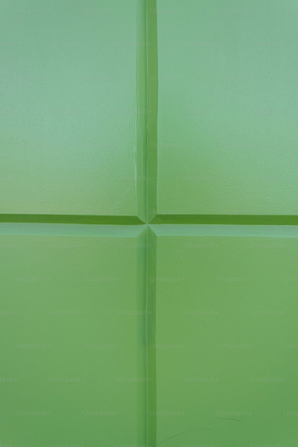 a close up of a green tile wall