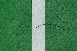 a green and white wall with a crack in it