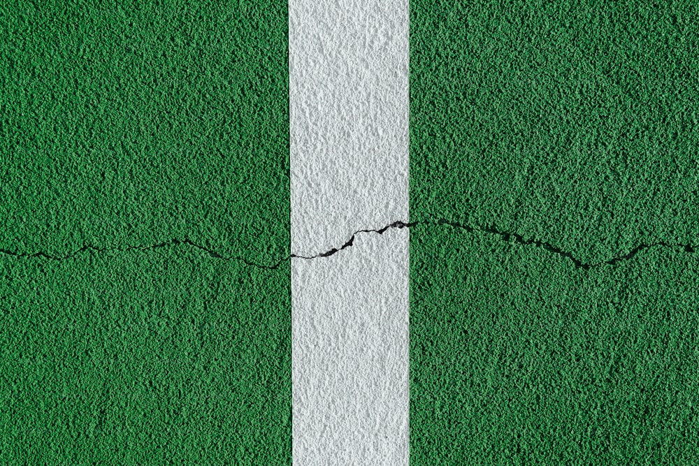 una pared verde y blanca con una grieta