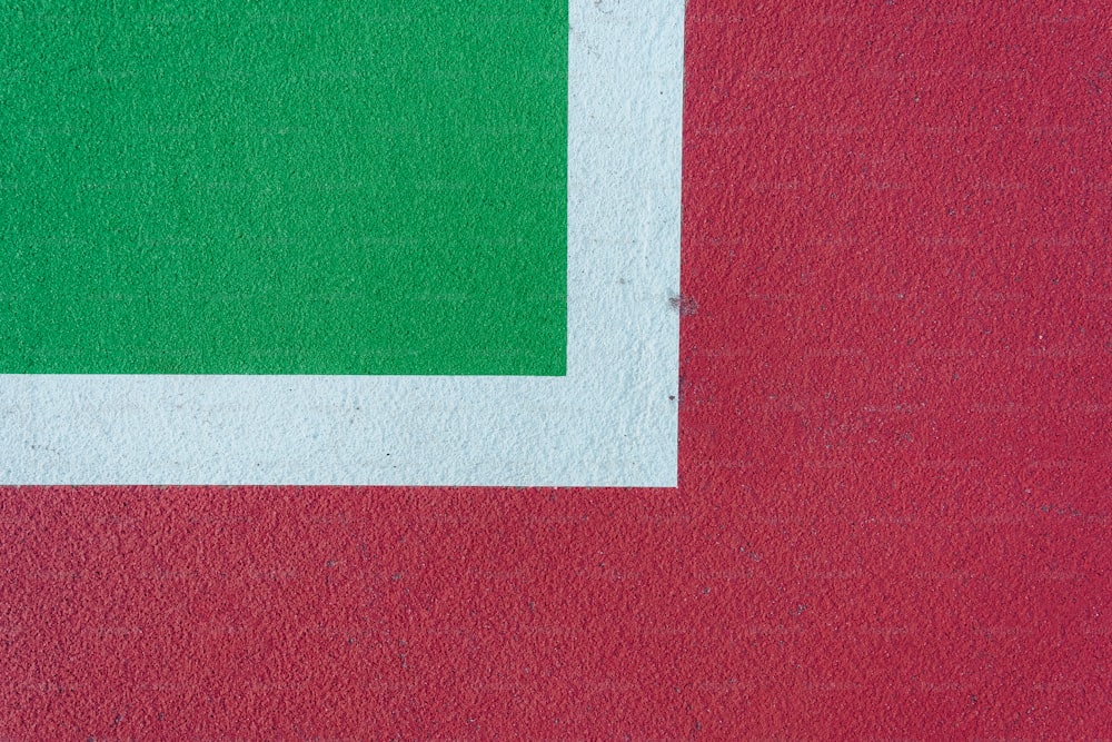 a red and white wall with a green square