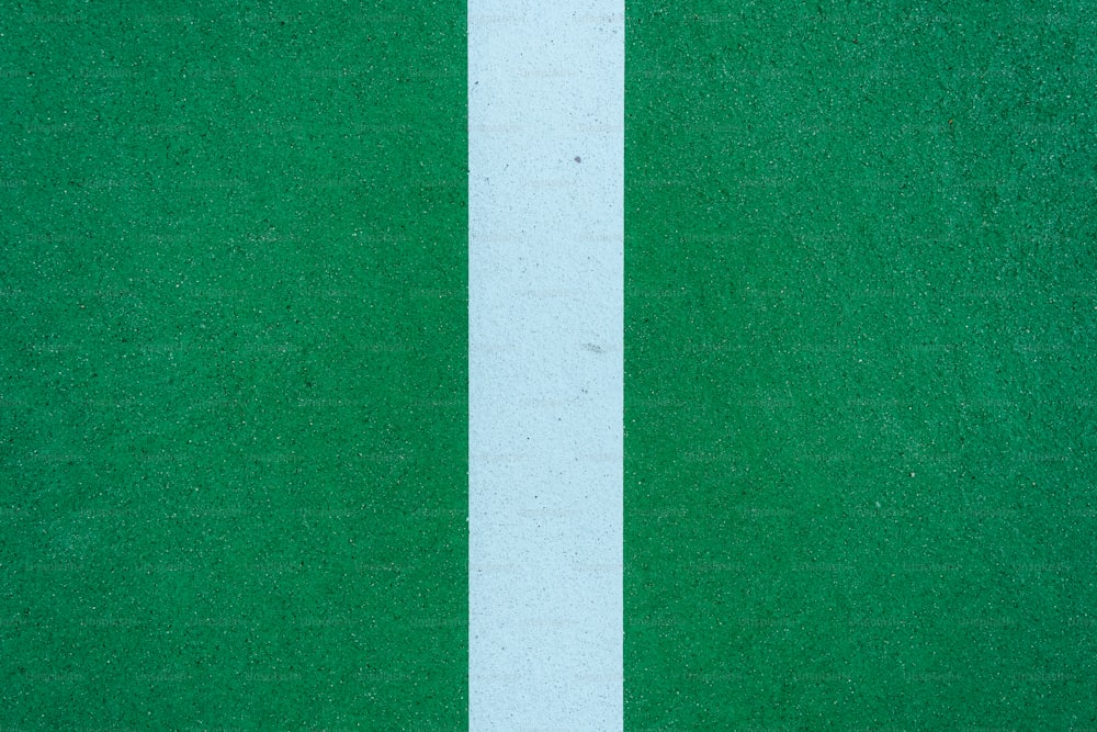 Un primer plano de una línea blanca sobre una superficie verde