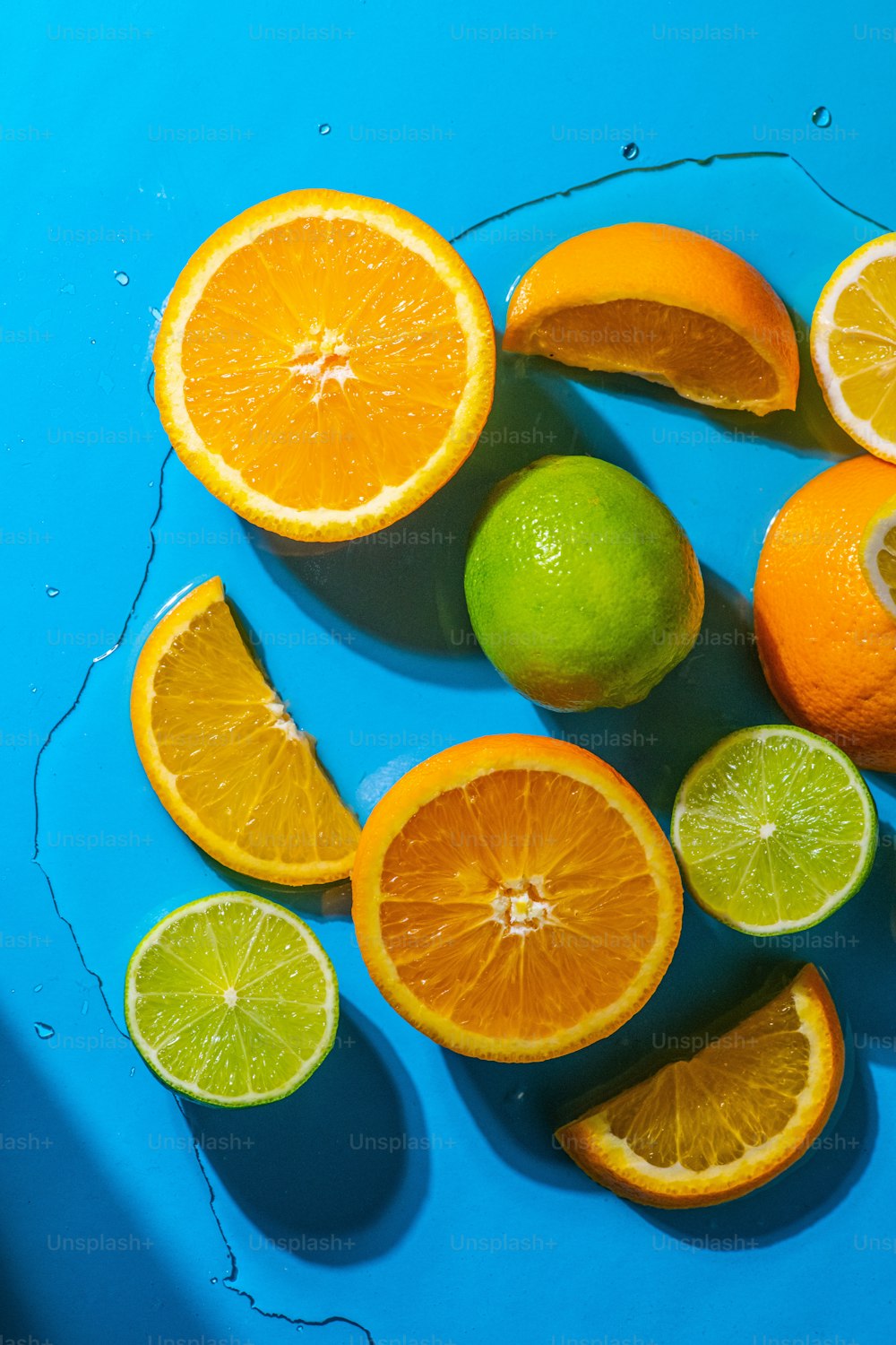 a group of oranges and limes on a blue surface