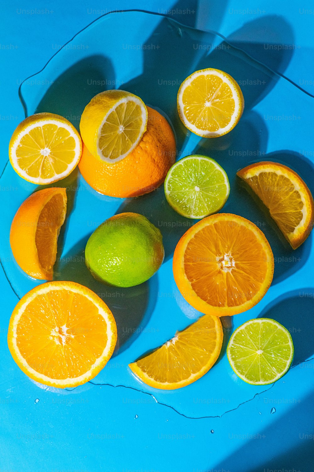 a blue plate topped with oranges and limes