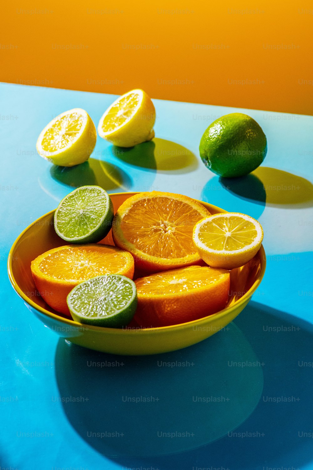 a bowl of oranges and limes on a table