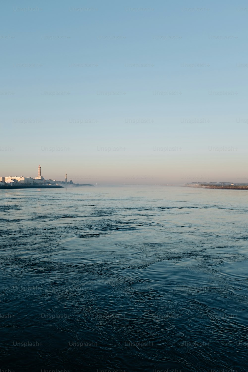 a body of water with a lighthouse in the distance