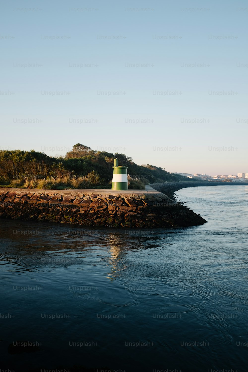 a light house sitting on the edge of a body of water