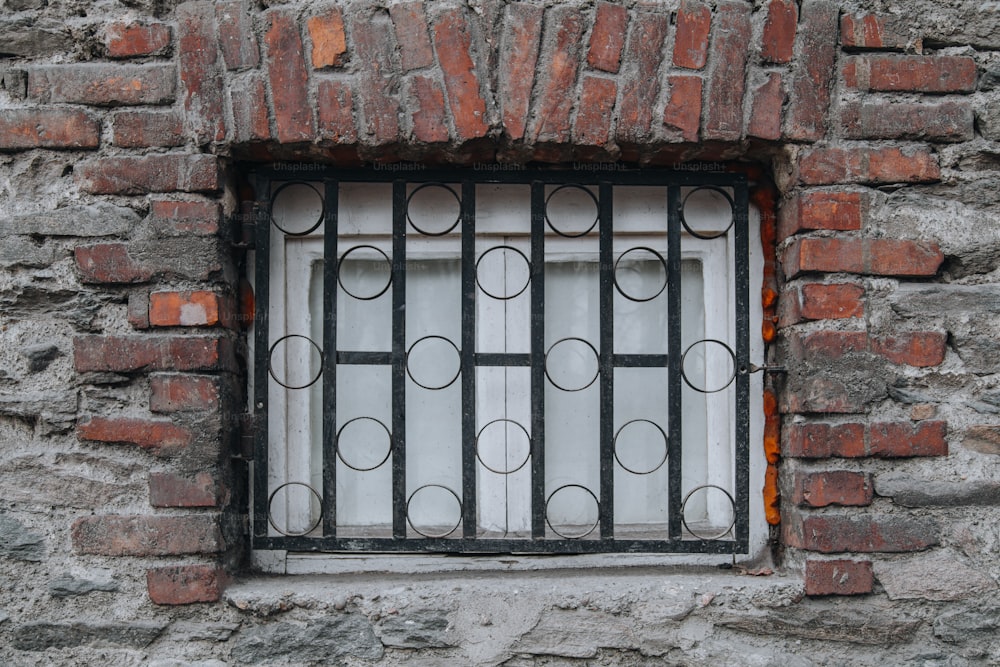 une fenêtre dans un mur de briques avec des barreaux dessus