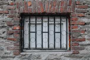 a window in a brick wall with bars on it