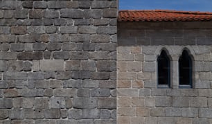 uma parede de pedra com duas janelas e um telhado vermelho