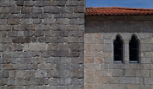 a stone wall with two windows and a red roof