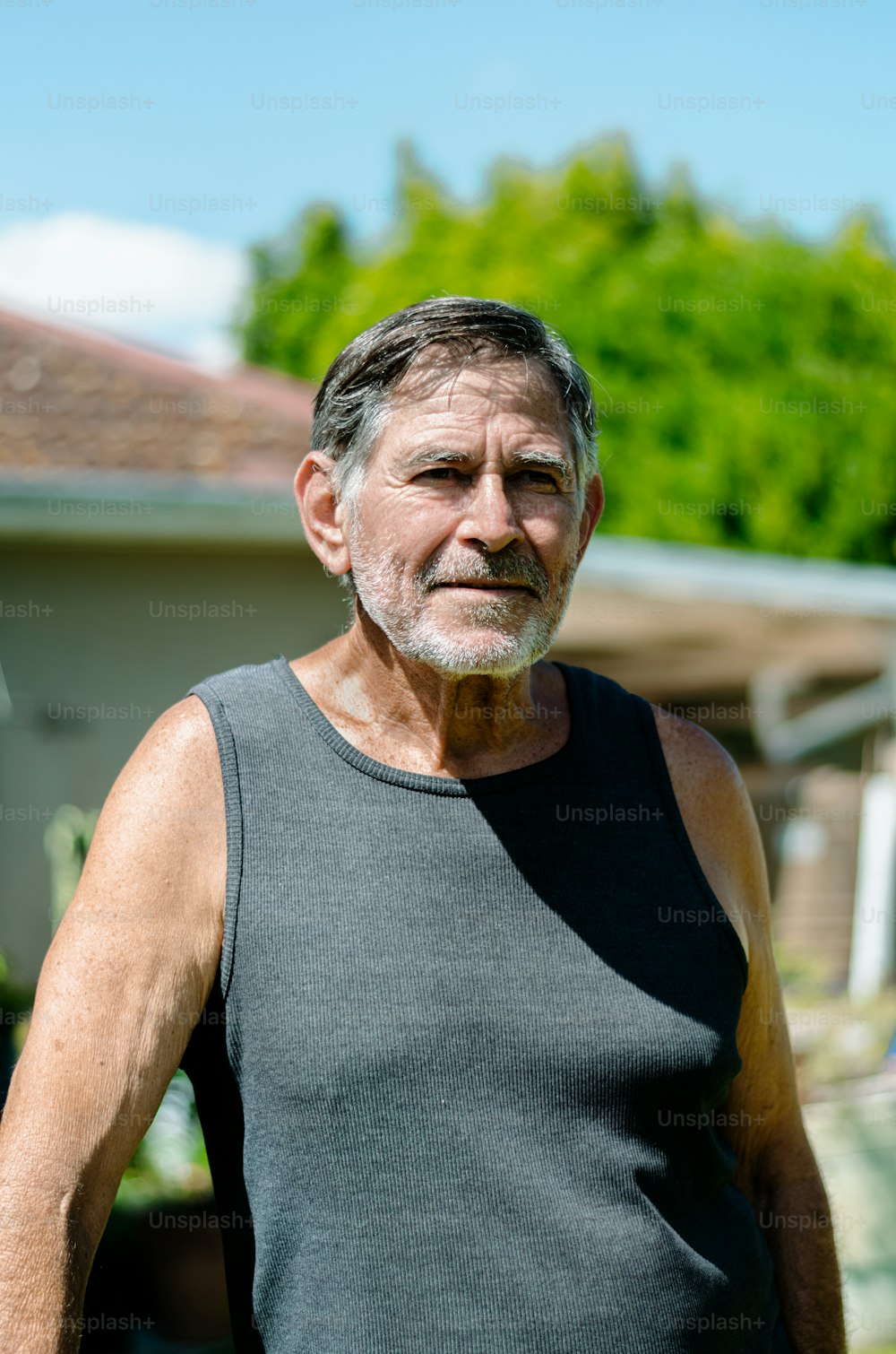 an older man standing in front of a house