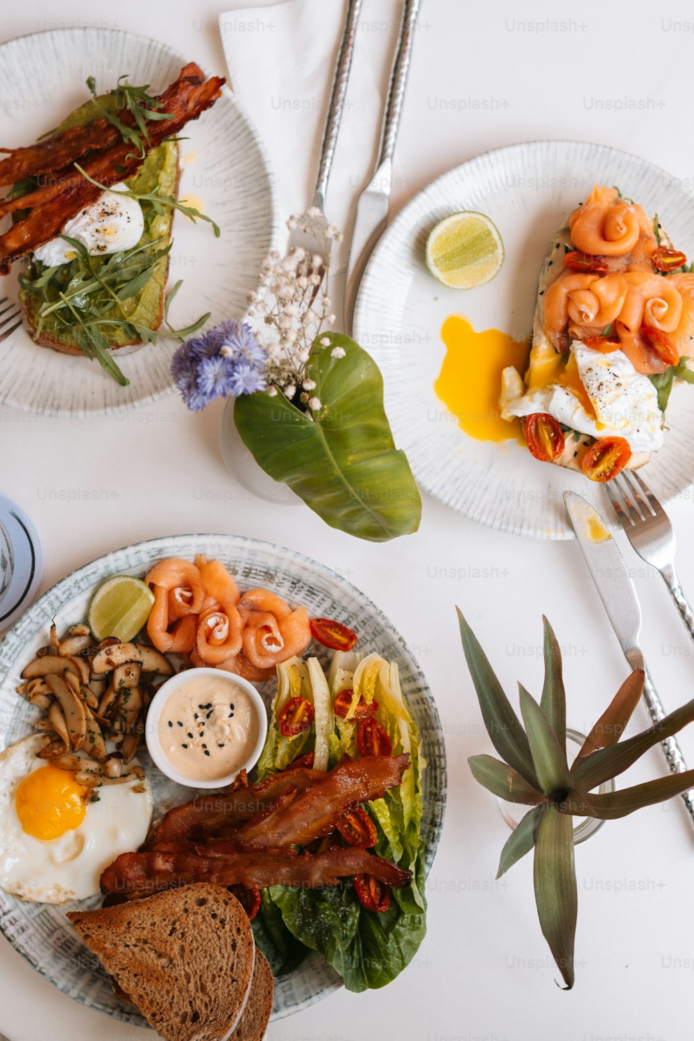 dois pratos de comida em uma mesa com utensílios