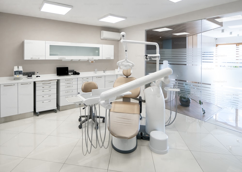 um consultório odontológico com uma cadeira odontológica e equipamentos