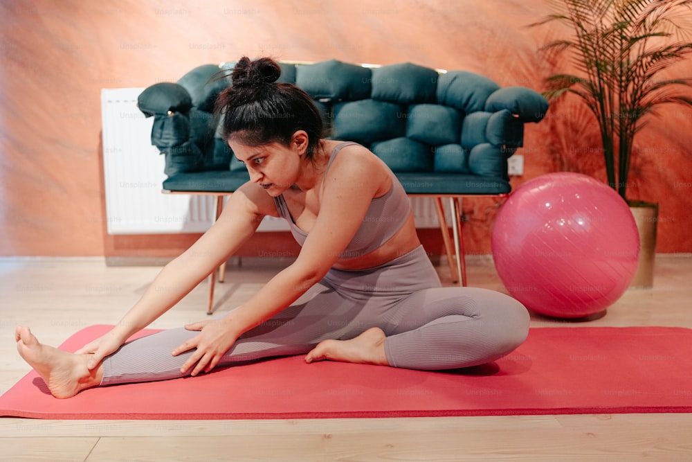 Una donna seduta su un tappetino da yoga in una stanza