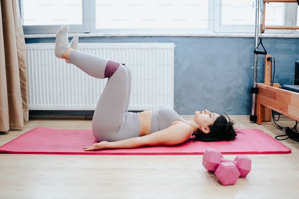 a woman laying on a yoga mat in a room