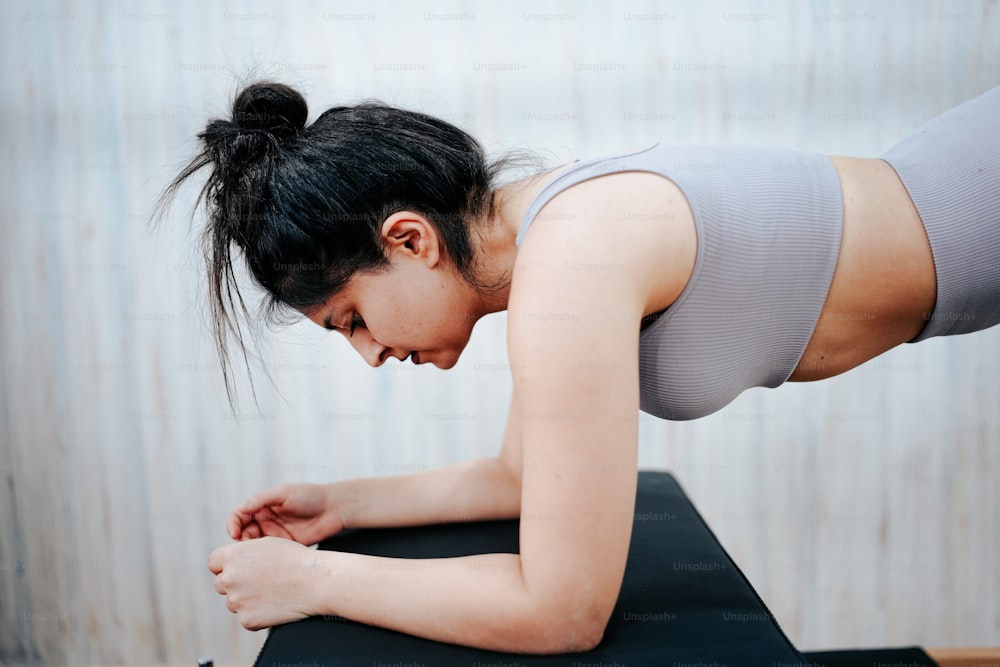 Una mujer está haciendo yoga en una colchoneta