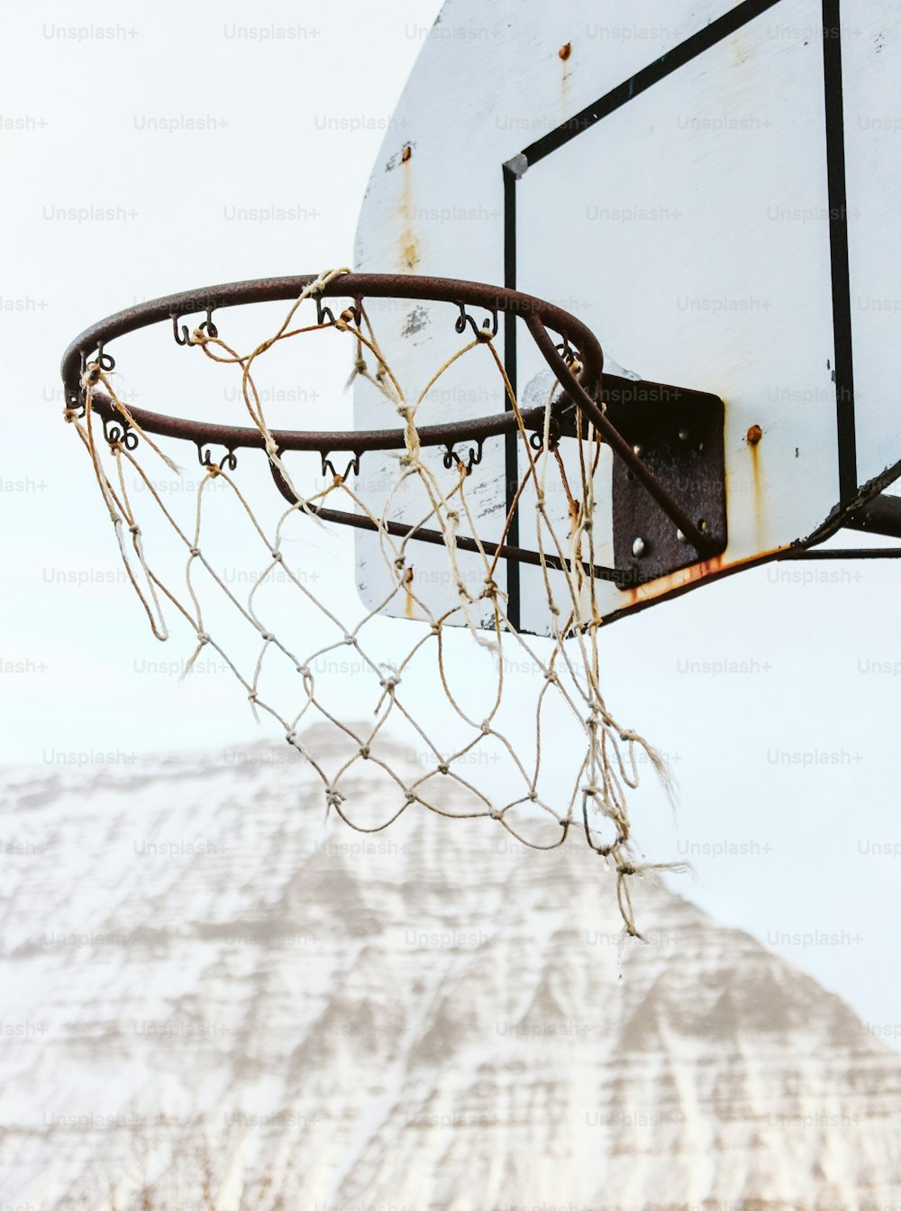 a close up of a basketball hoop with a mountain in the background