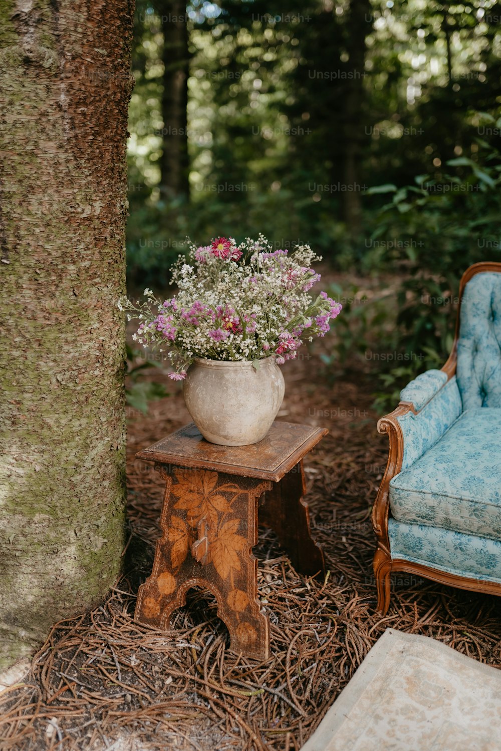 une chaise et une table avec un vase de fleurs dessus