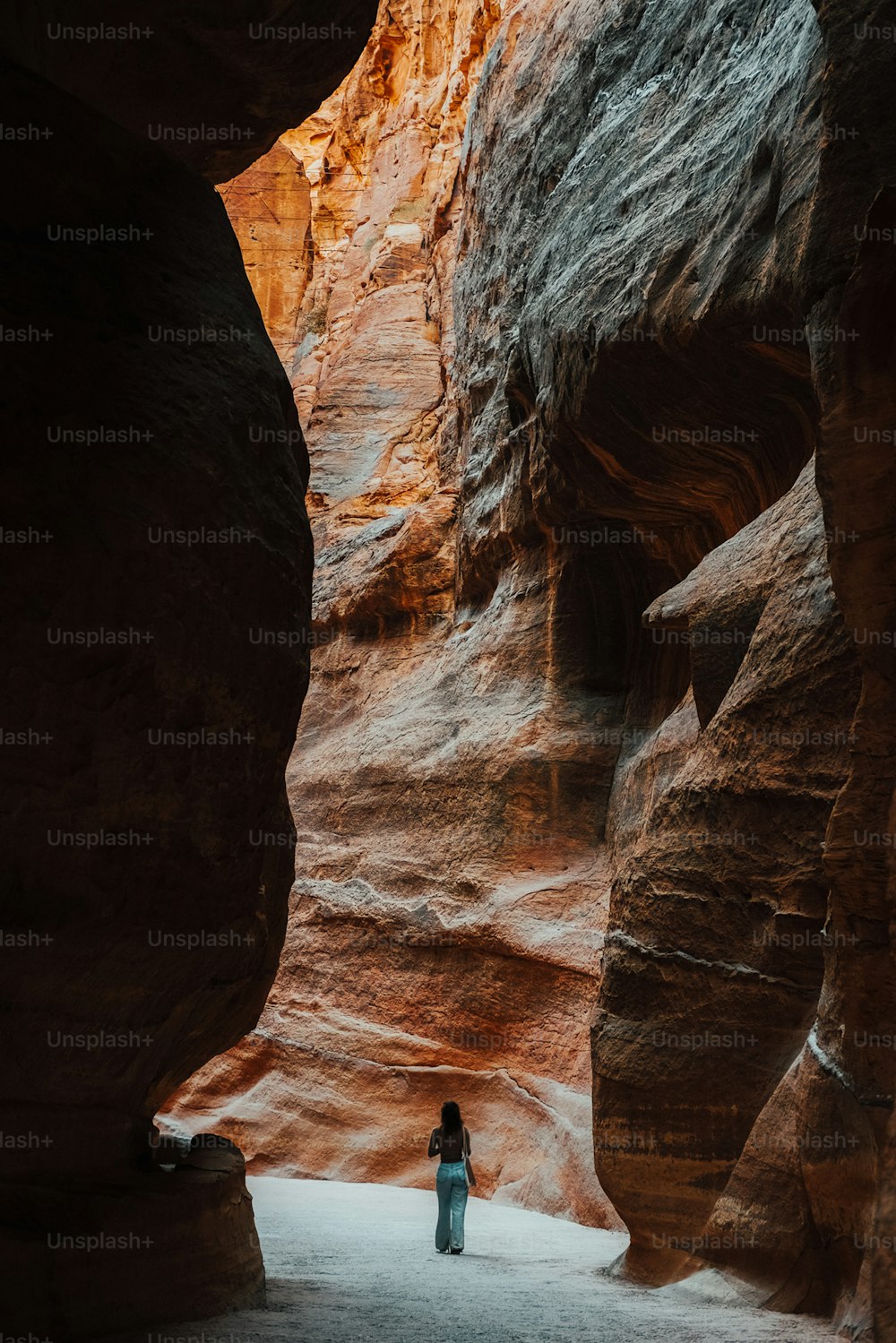 Una persona parada en una ranura estrecha en un cañón
