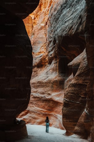 a person standing in a narrow slot in a canyon