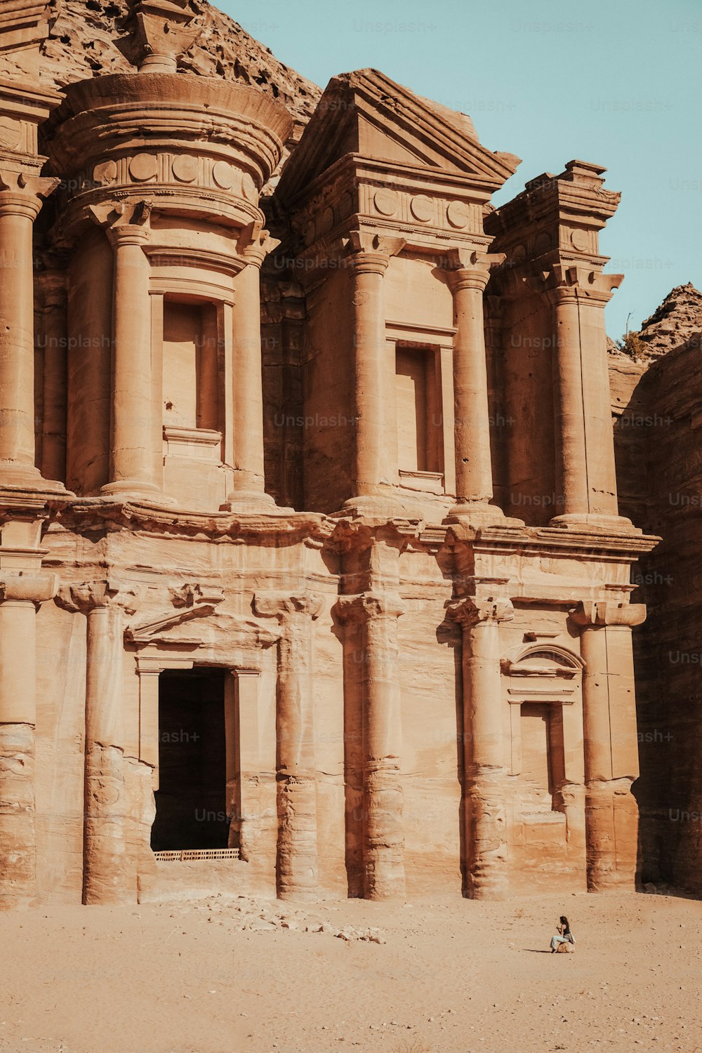 a large stone building with a person standing in front of it