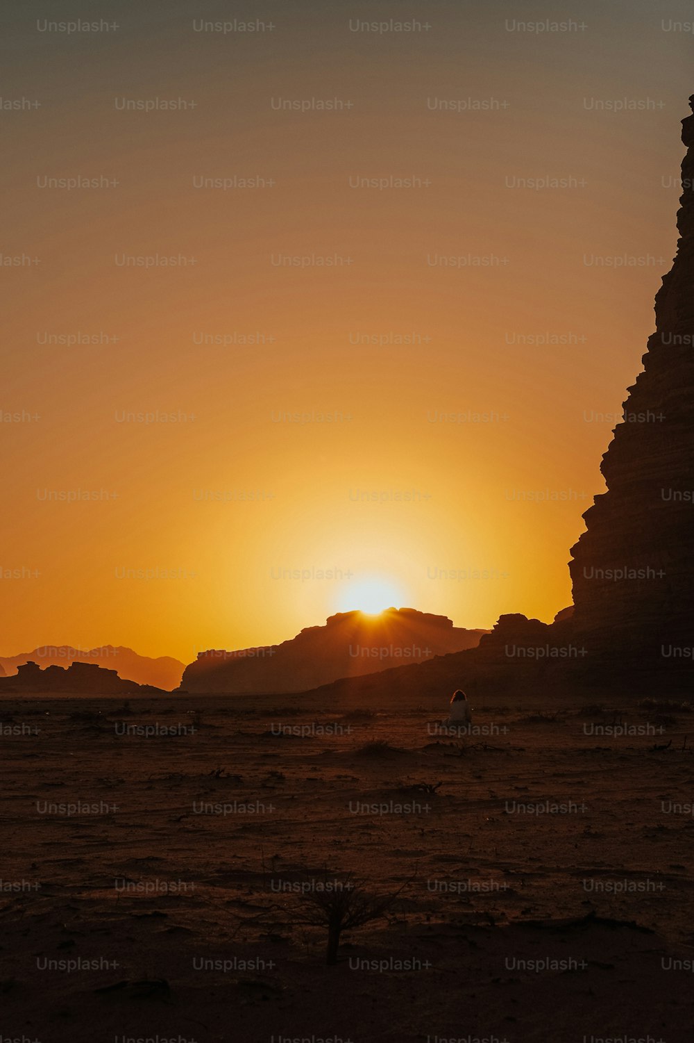 Le soleil se couche derrière une pyramide dans le désert