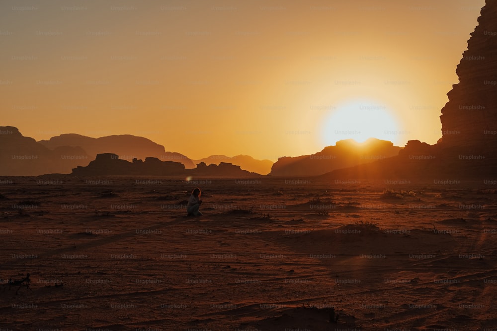 Une personne marchant dans le désert au coucher du soleil