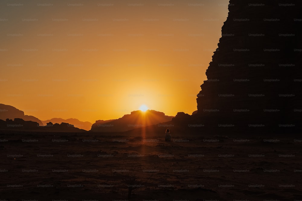 太陽は砂漠の風景に沈んでいます