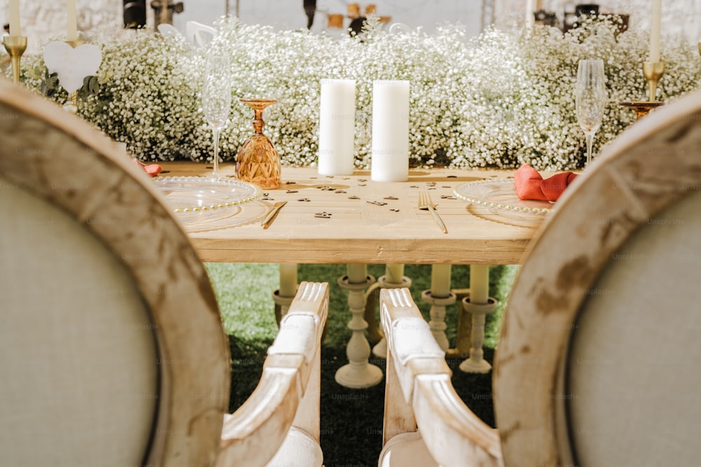 a wooden table topped with two white candles
