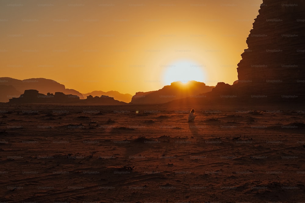 太陽は岩だらけの砂漠に沈んでいます
