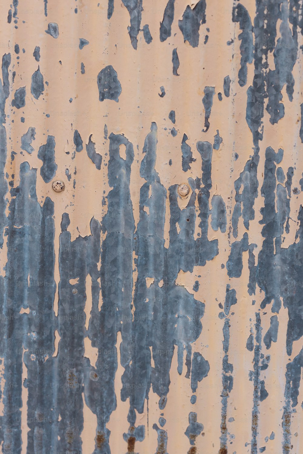 una superficie metálica oxidada con pintura azul y blanca