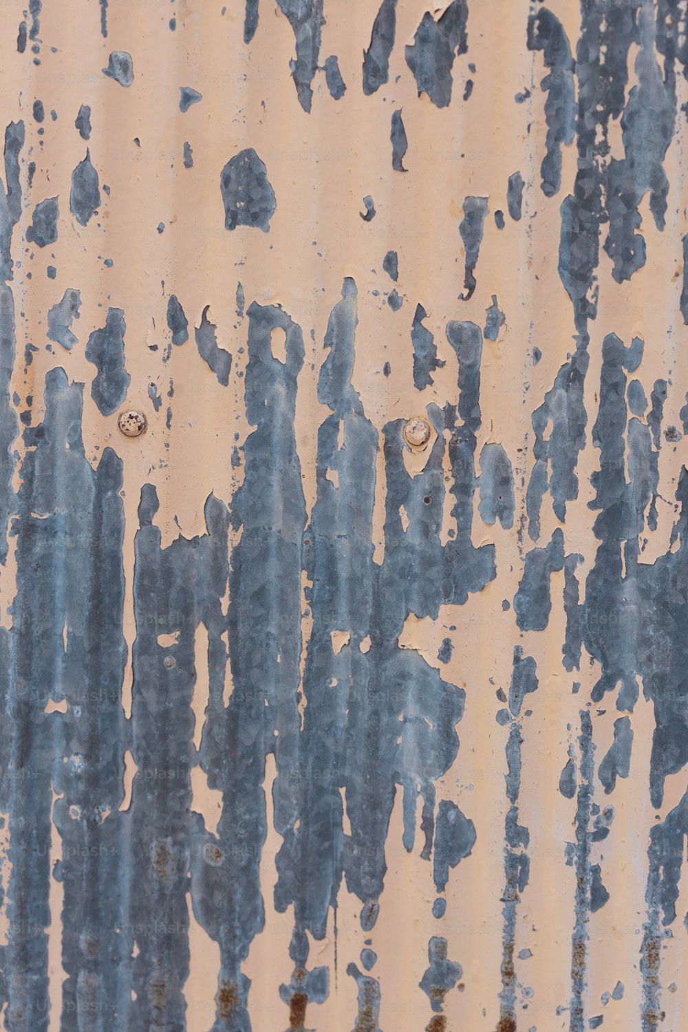 una superficie metálica oxidada con pintura azul y blanca