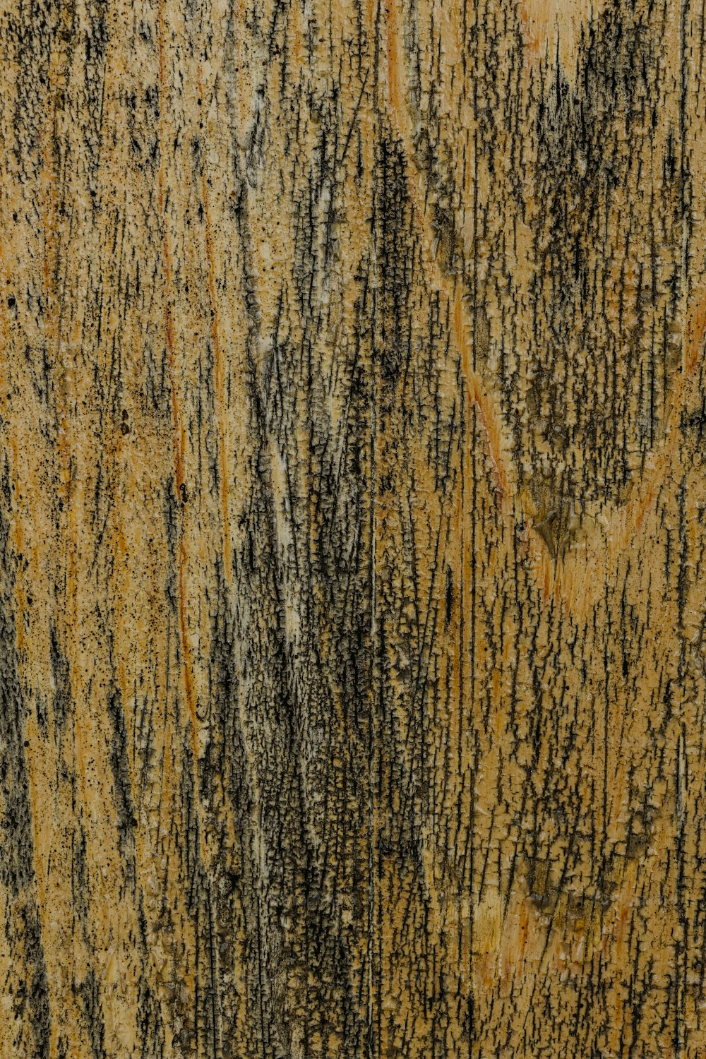 a close up of a wooden surface with black and yellow paint