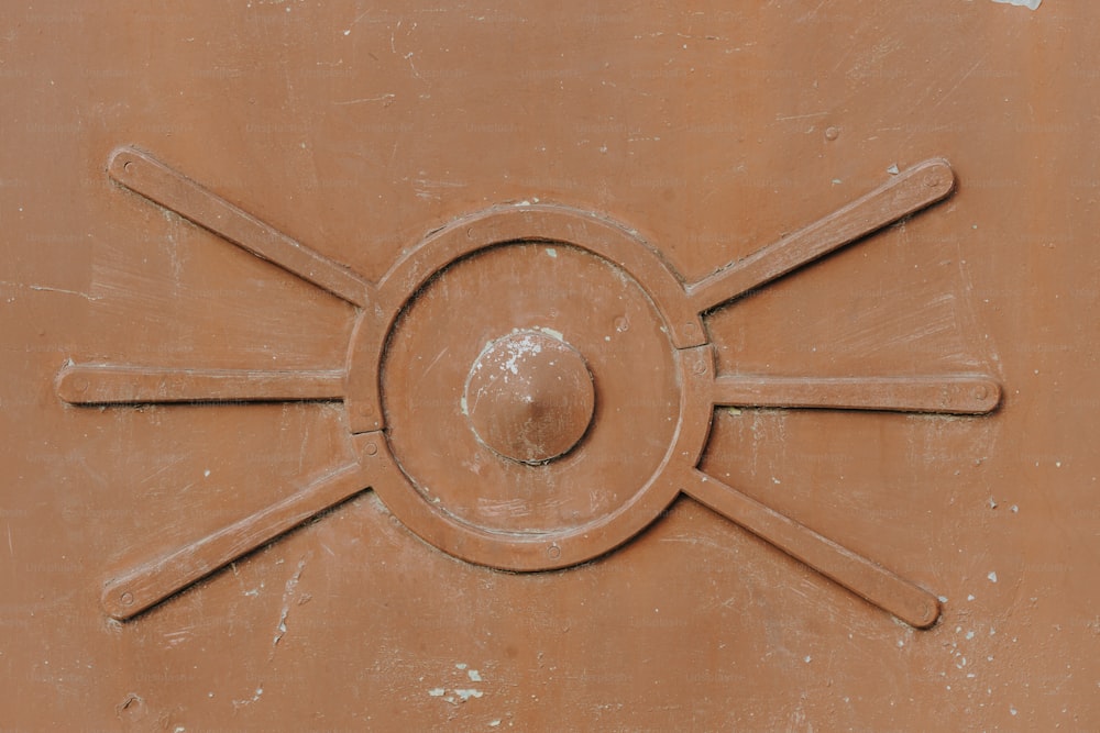 a close up of a brown wall with a circular design