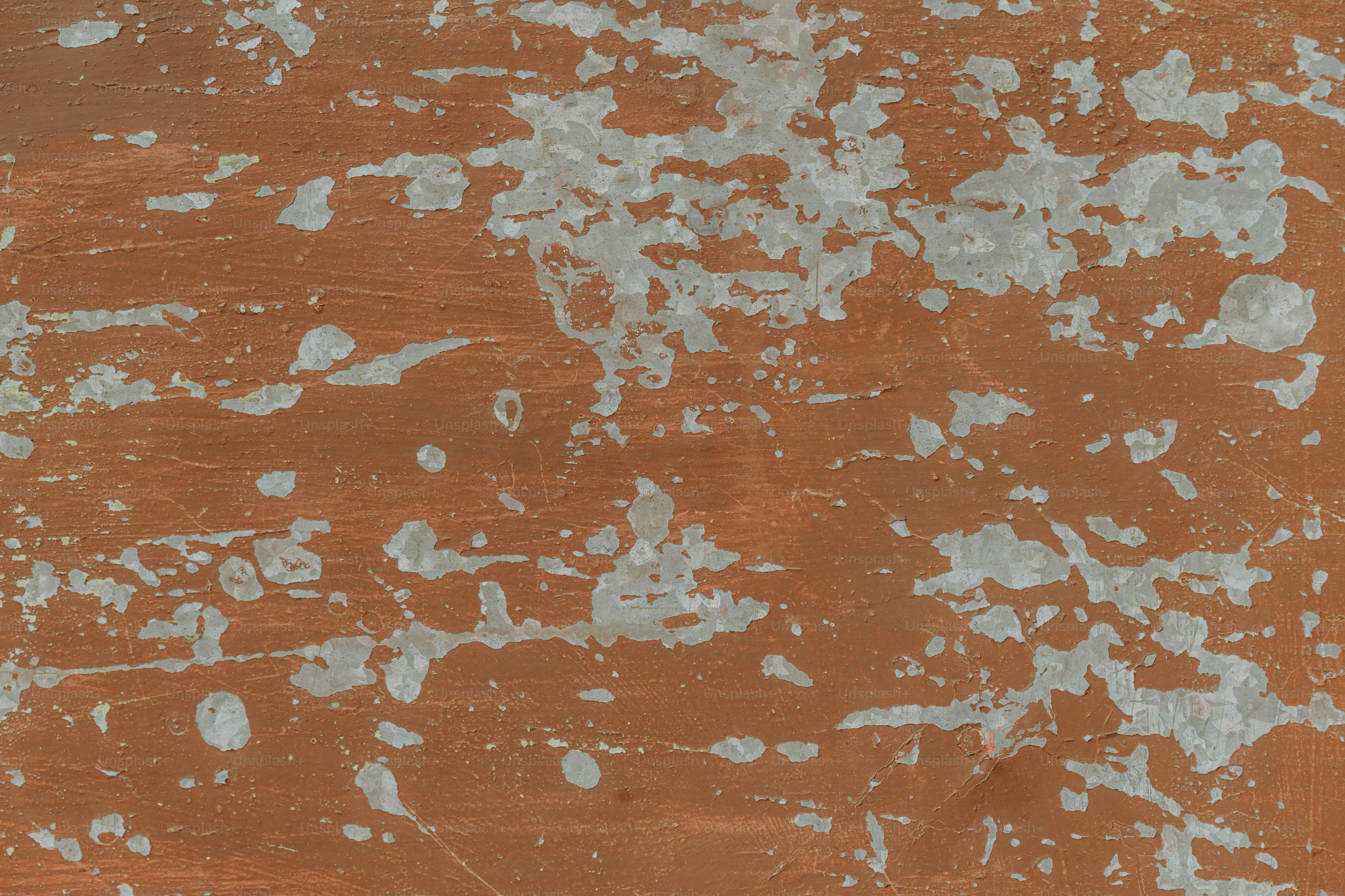 a brown and white wall with white paint on it