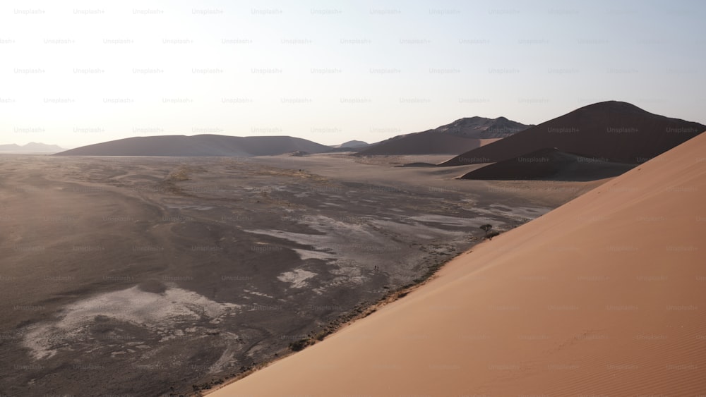 Un deserto con dune di sabbia e montagne sullo sfondo