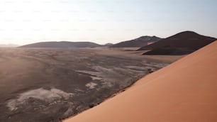 a desert with sand dunes and mountains in the background