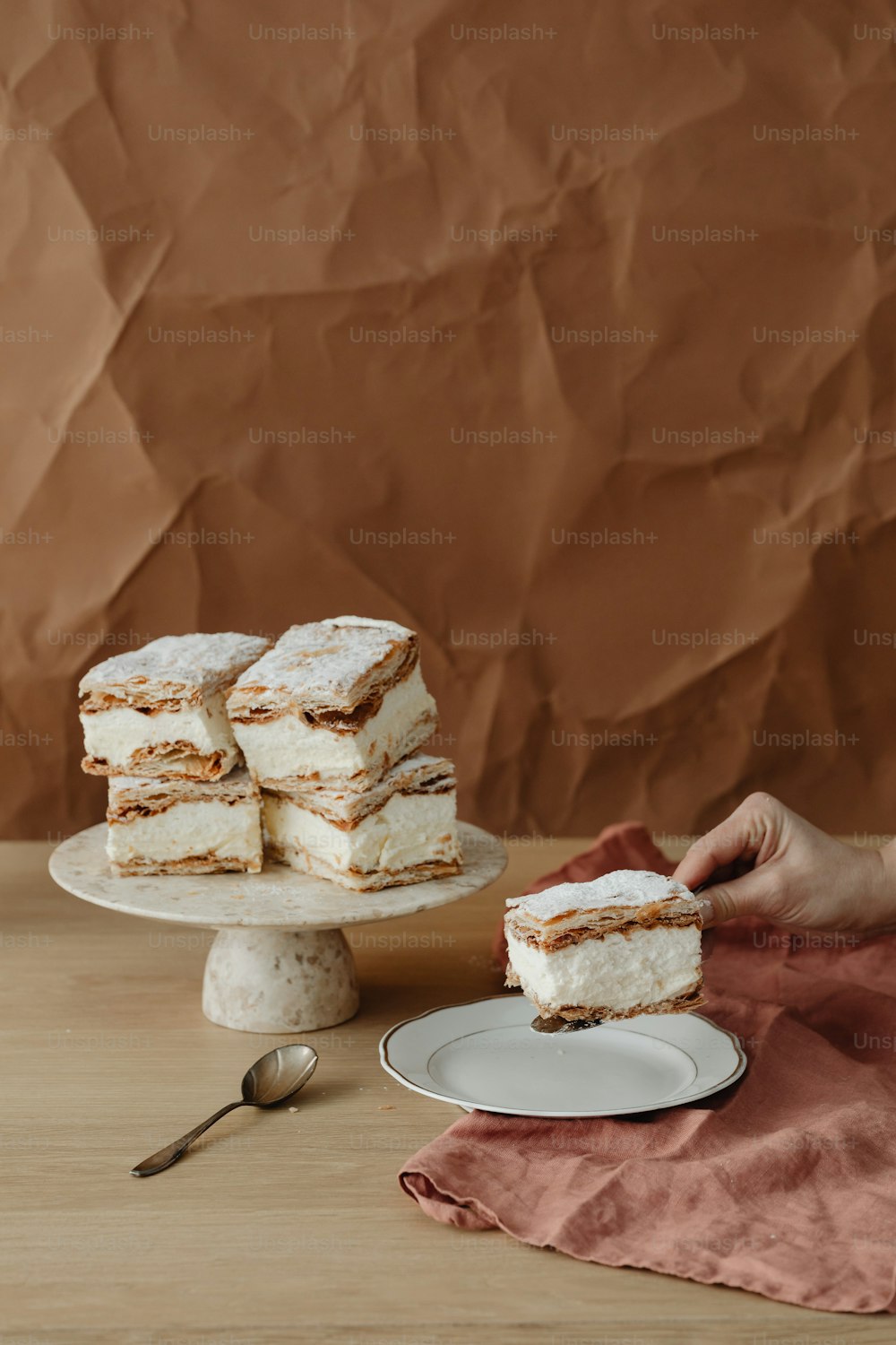 a person holding a piece of cake on a plate