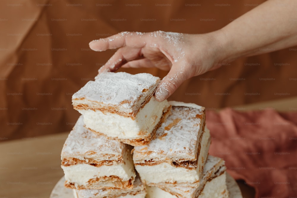 a hand reaching for a piece of cake