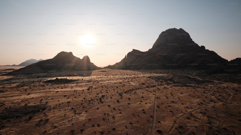 太陽は砂漠の山々に沈んでいます