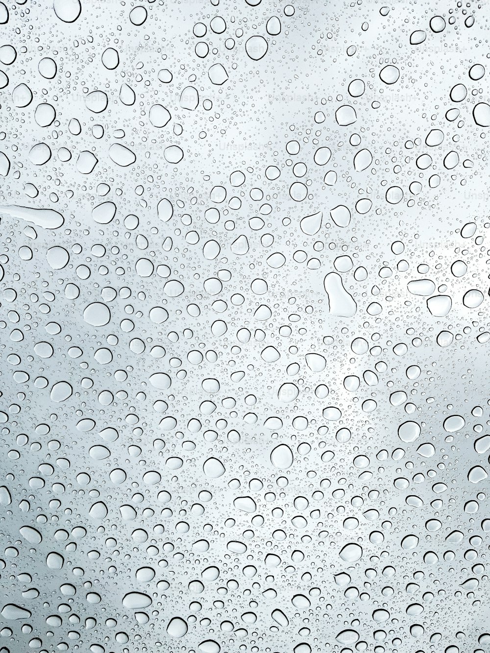 un primo piano di una finestra con gocce d'acqua