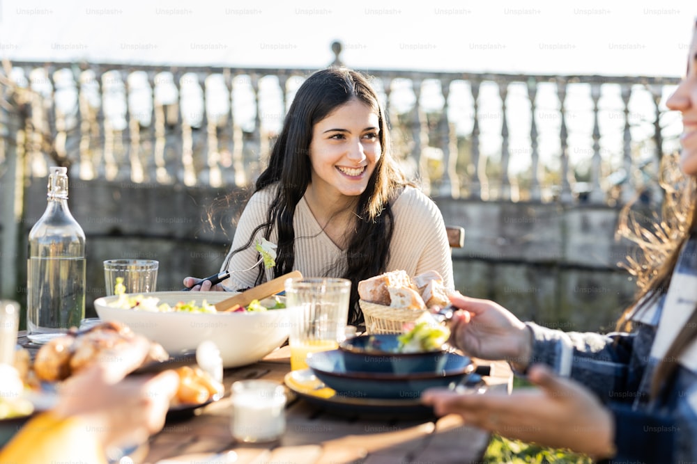 a group of women sitting around a table eating food